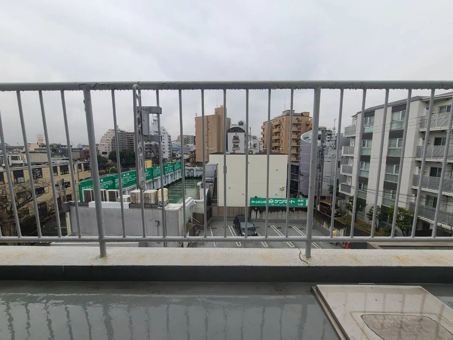 都市の風景、バルコニーから見えるビル群と鉄道、曇り空