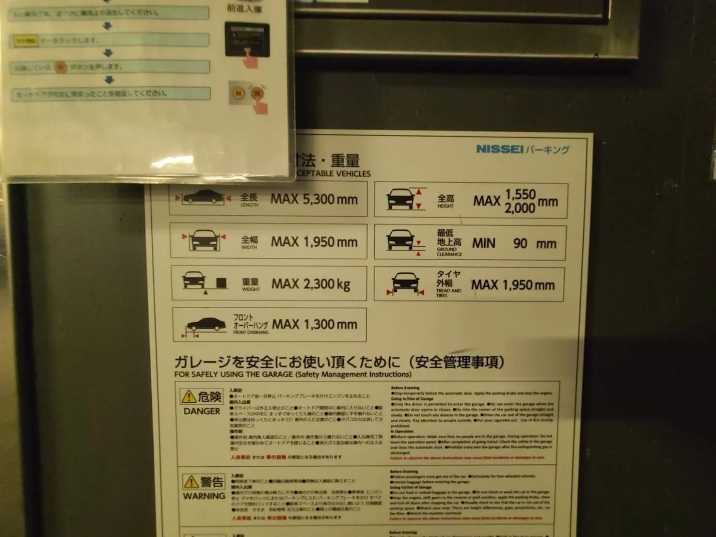 ガレージ利用規則の案内表、車種ごとの最大サイズと重量制限、安全使用に関する注意事項が記載された掲示物