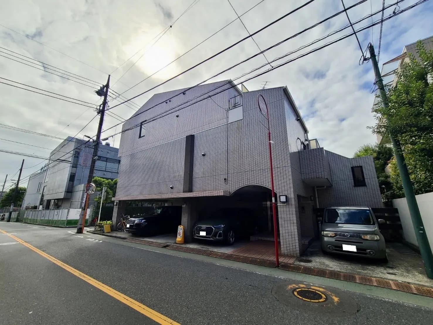 現代的な外観の都市型マンション、屋根付き駐車場あり、緑豊かなエリア