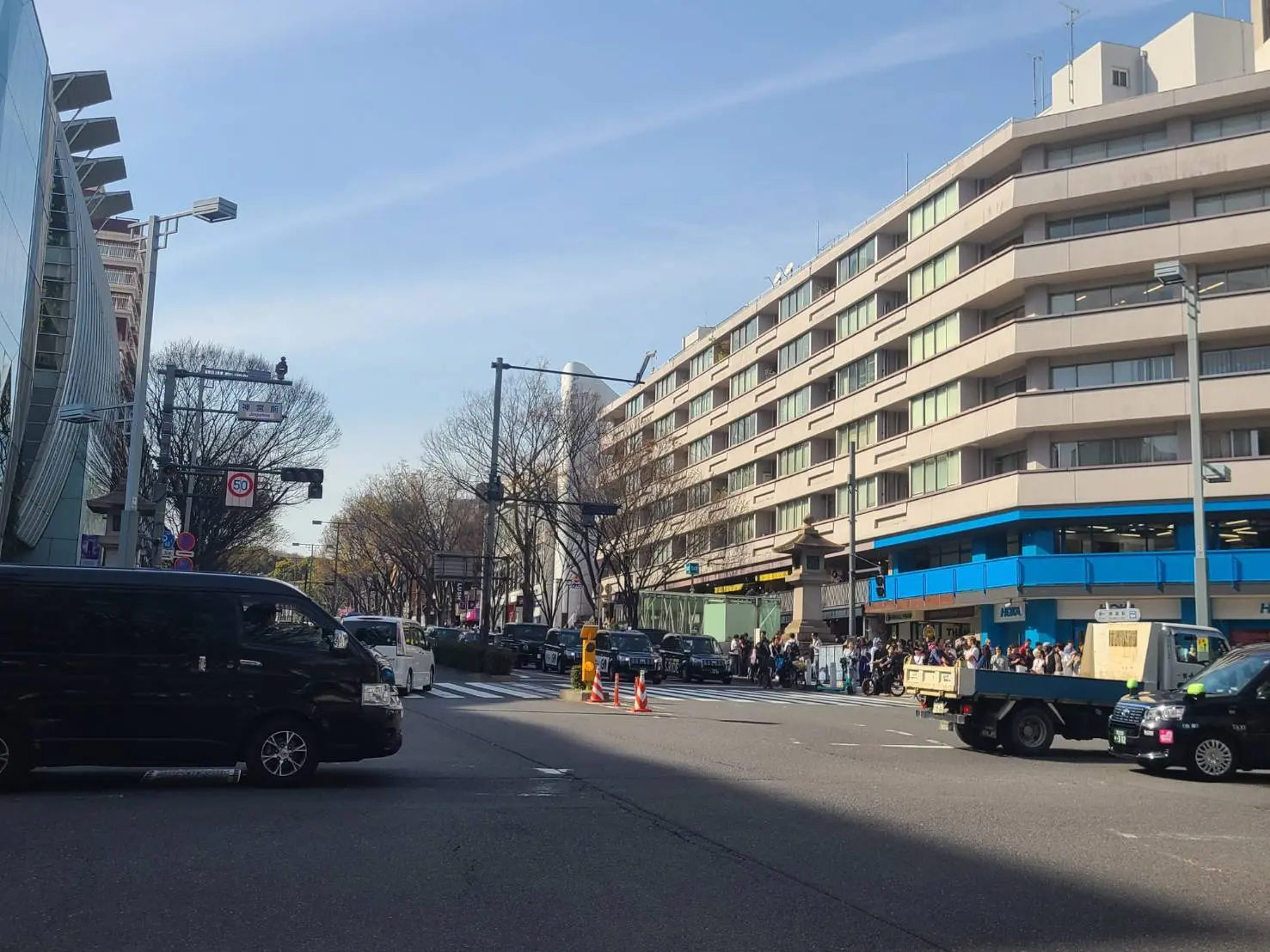 日本の都市部の交差点、車と歩行者が行き交う賑やかな風景