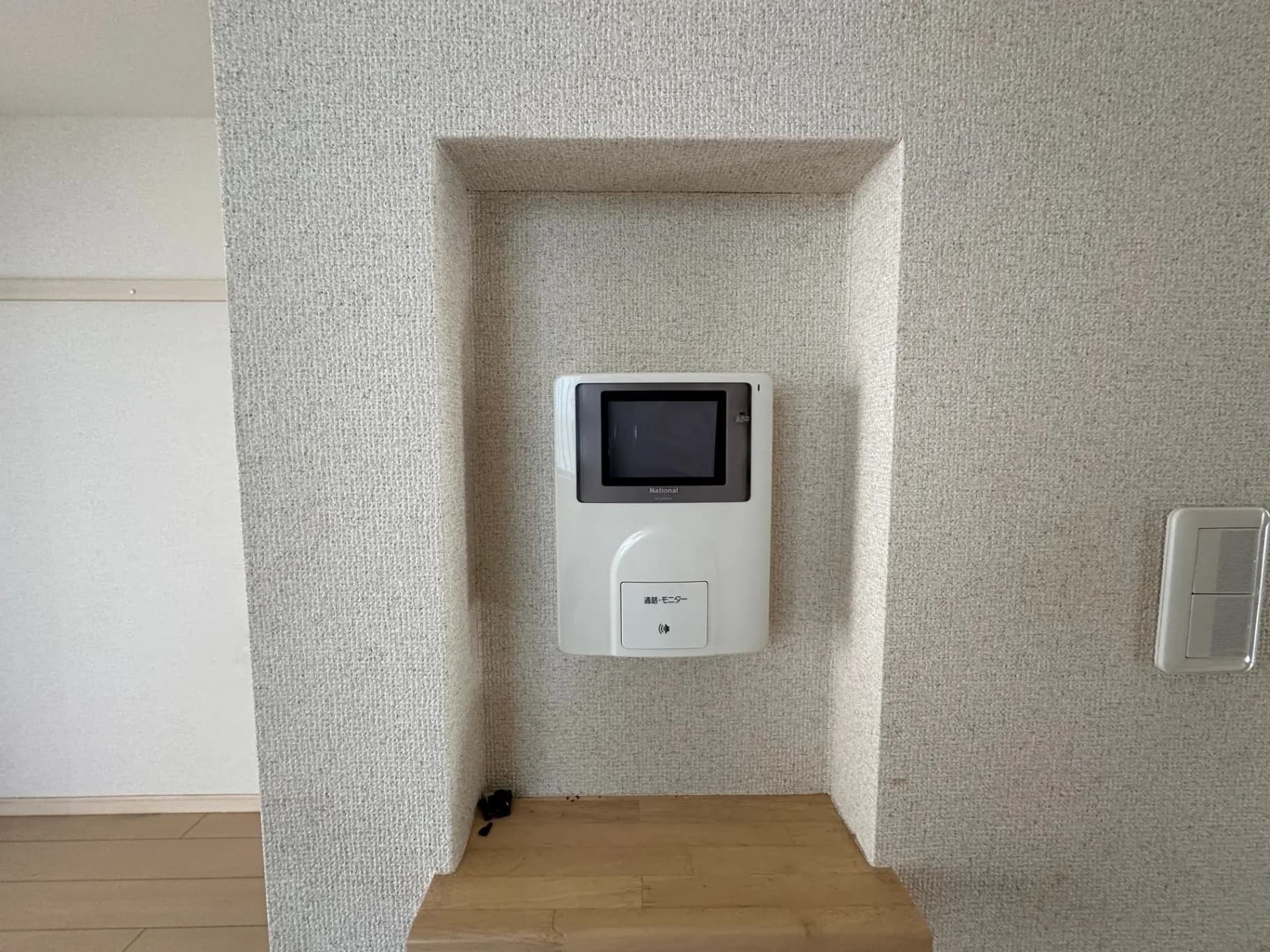 モダンな住宅の壁に取り付けられたインターホンとスイッチパネル、シンプルなデザインのインテリア