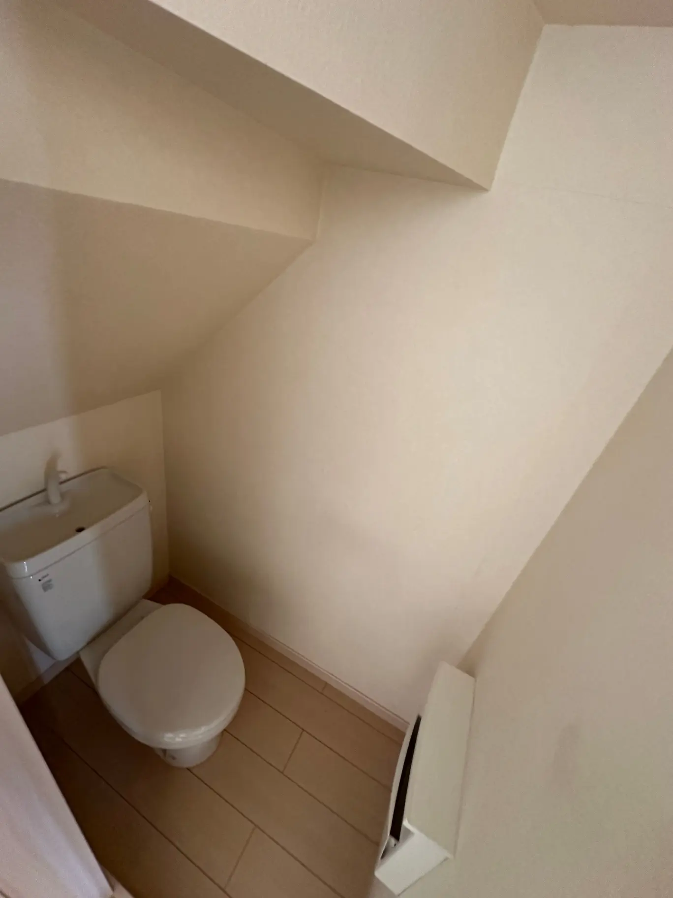 シンプルで清潔感のあるトイレ、手洗い付きタンクレストイレ、木目調の床タイル