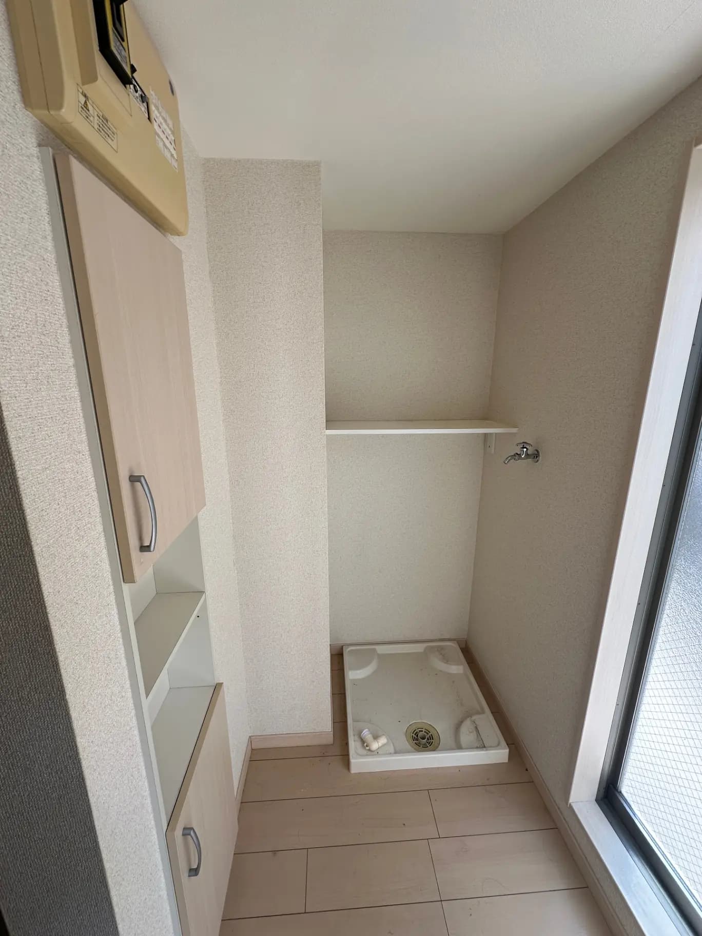 狭い洗面スペース、シンプルなデザインの洗面台、窓から差し込む光