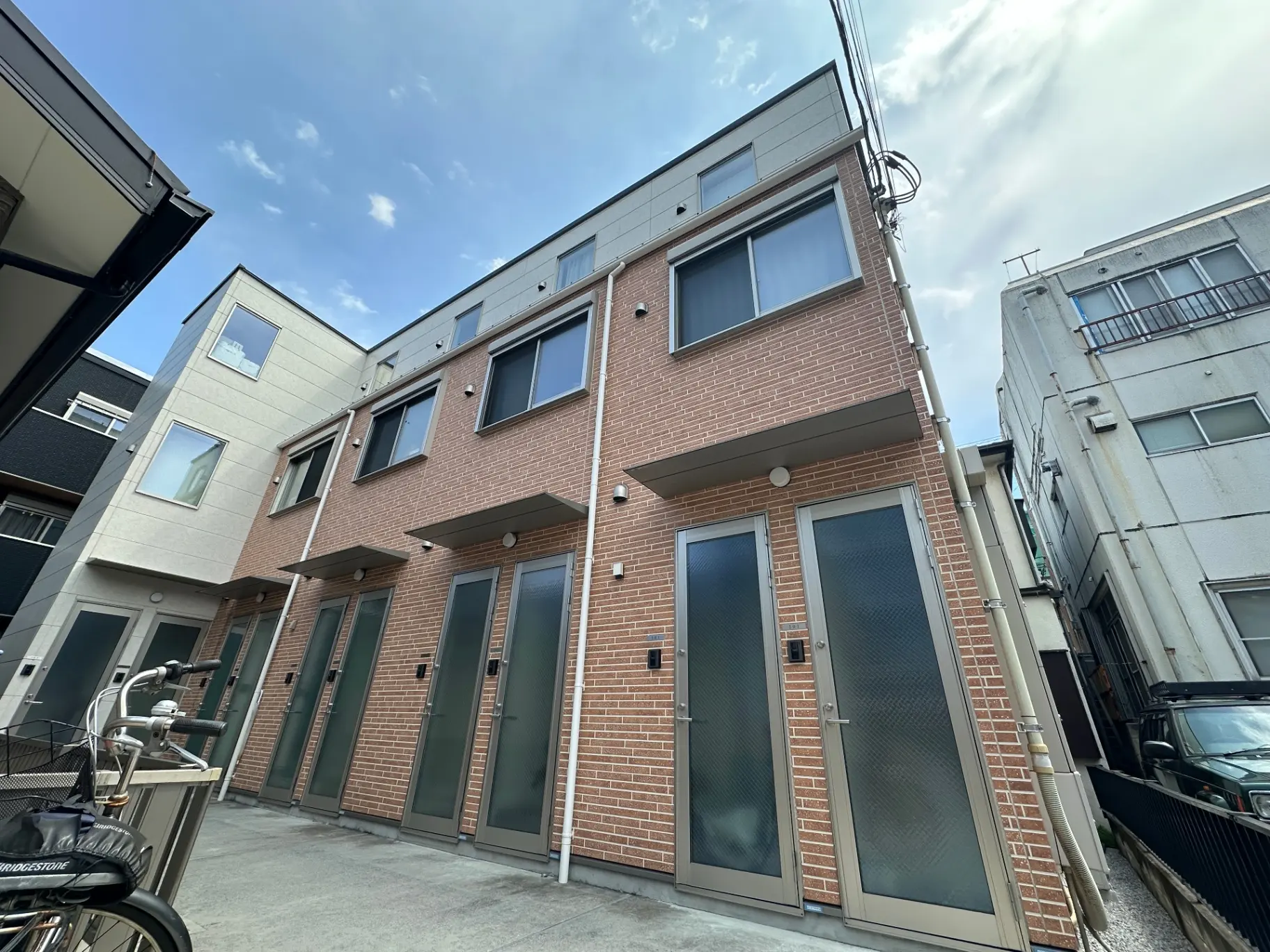 オシャレな外観の都市型アパートメント、レンガ調の壁とクリアなガラス窓