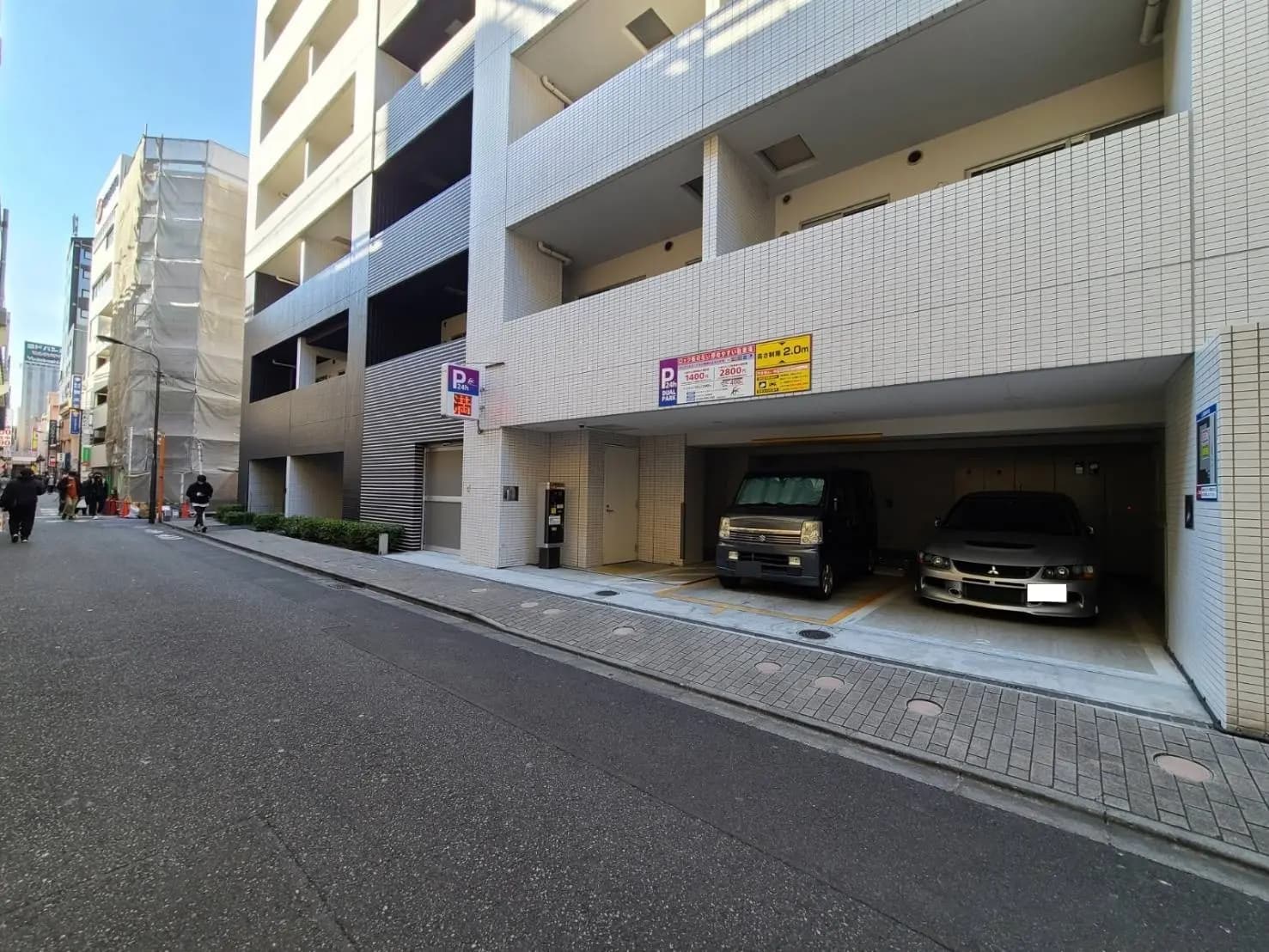 都心の立体駐車場、車2台が駐車中の写真