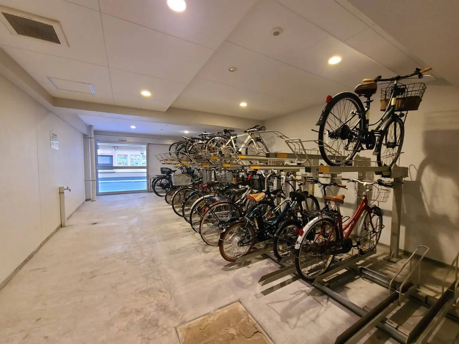 清潔で整理されたマンションの自転車置き場、壁掛け収納ラックで多くの自転車収納可能