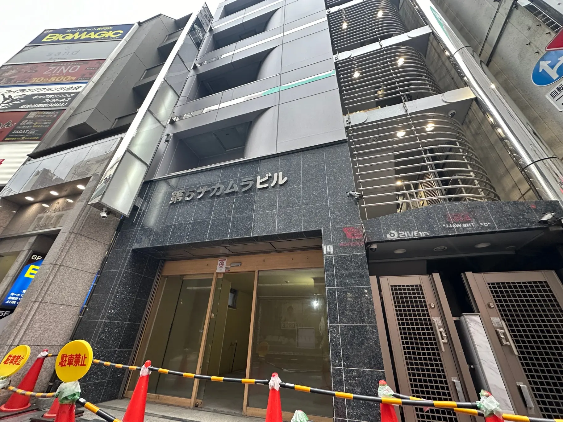 東京都の歓楽街にあるガラスフェンスと照明付きのモダンな雑居ビル、看板には「おすすめレビュー」と表示