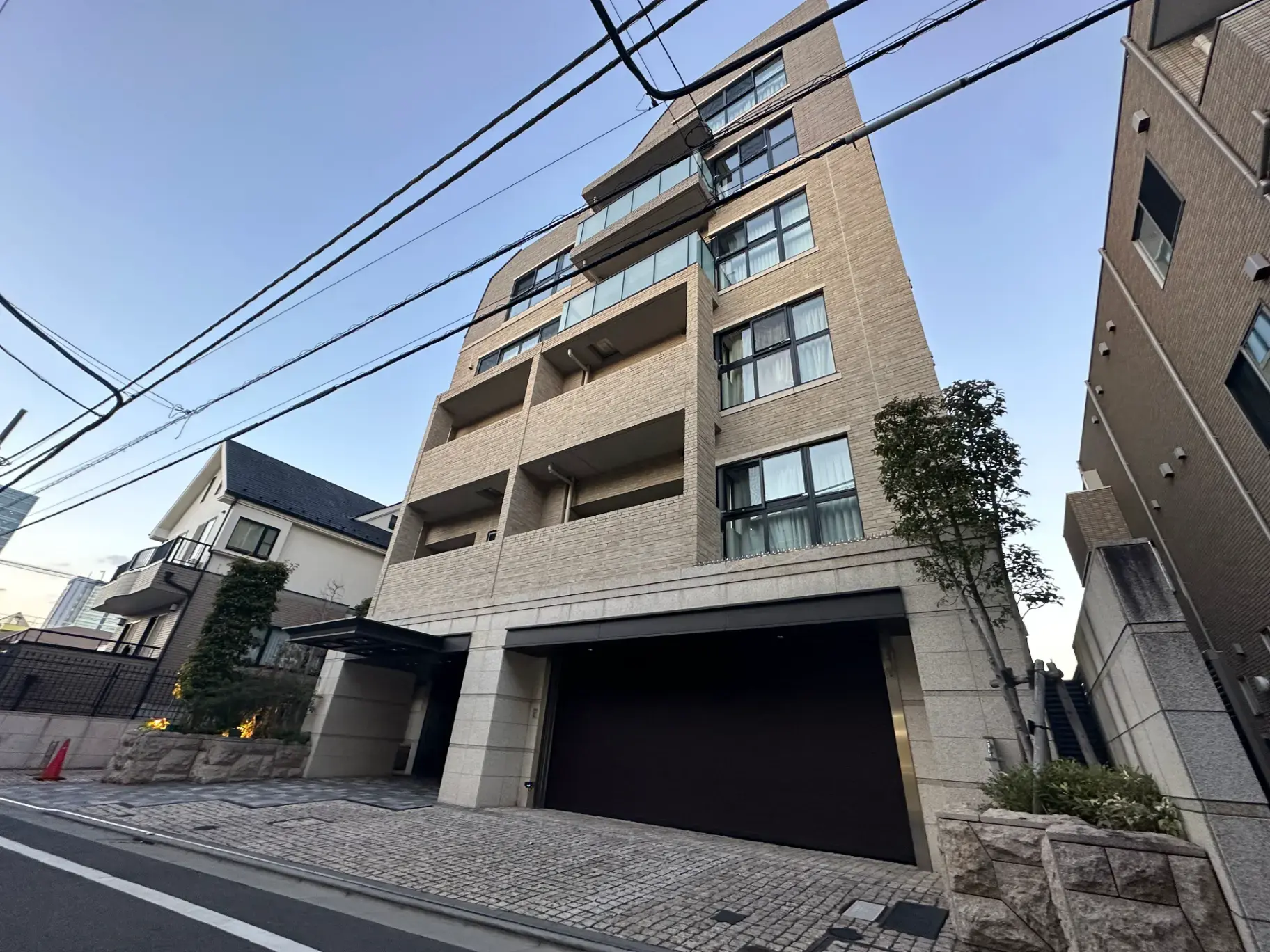 都市型マンションの外観、落ち着いた色調のファサード、整備されたエントランスエリア