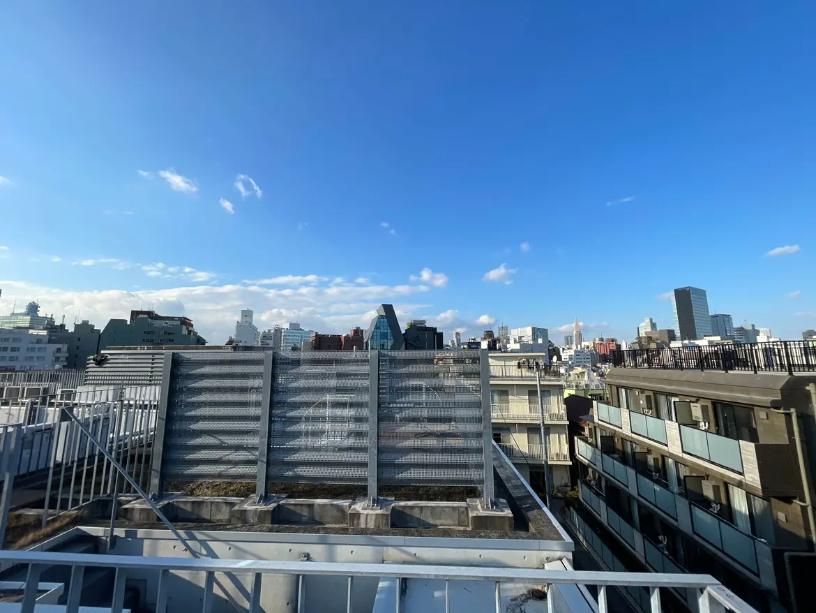 快晴の日の都市の景色、ビル群と青い空、遠くにランドマークの塔