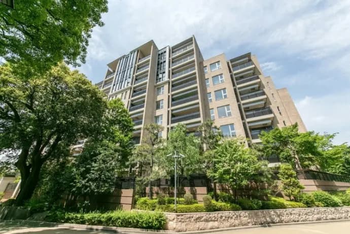 都心にあるモダンなデザインのマンション、緑豊かな公園の前の外観