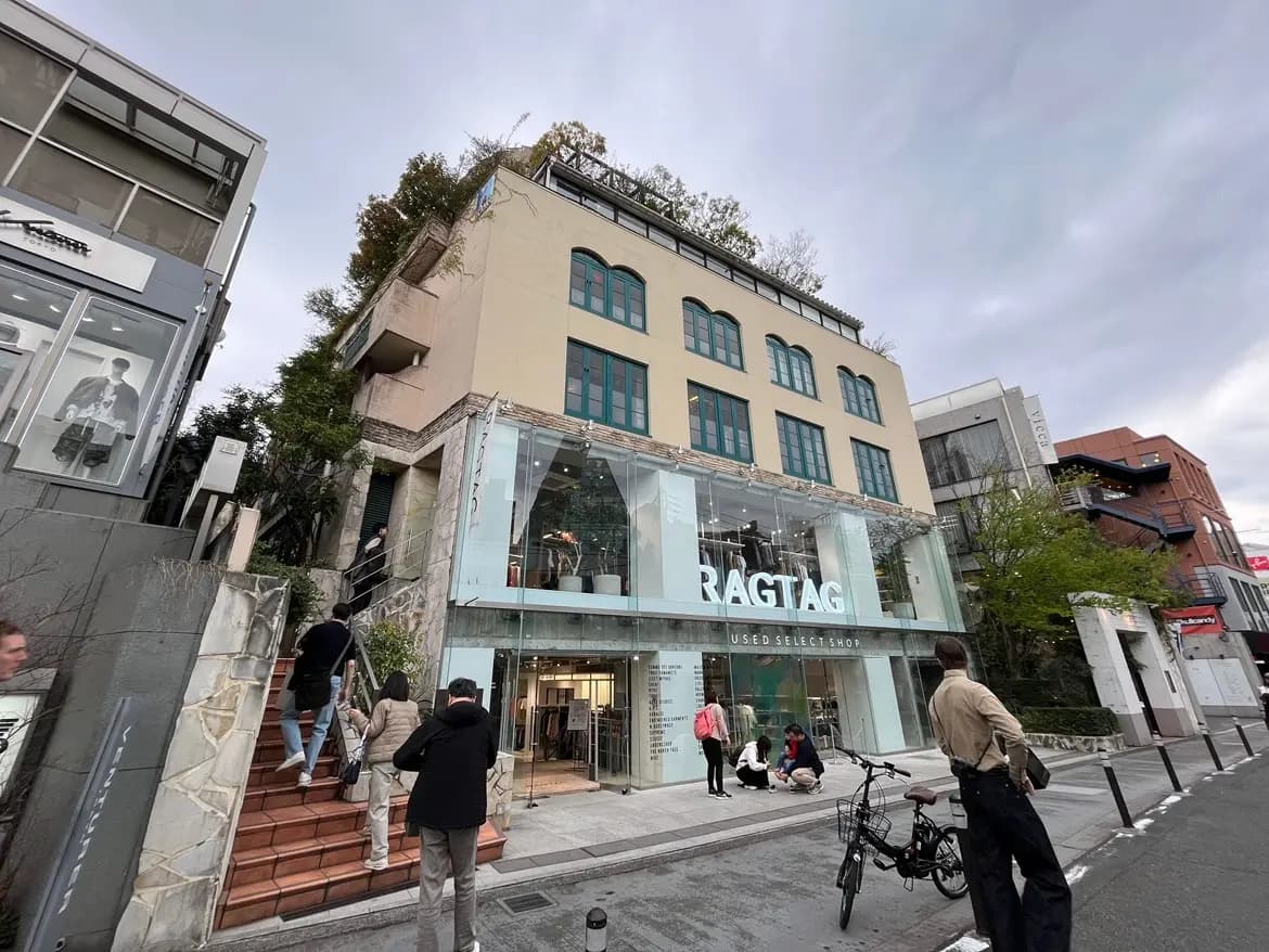 - ユニークなデザインの中古セレクトショップ「RAGTAG」、ガラス張りの外観と周囲の緑が調和した美しい店舗の景観