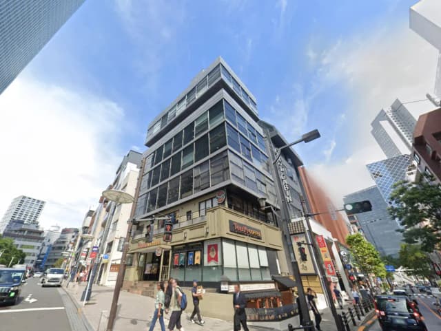 - 現代的なビルとその周辺の街並み、喫茶店やレストランが立ち並ぶ賑やかな通りの風景