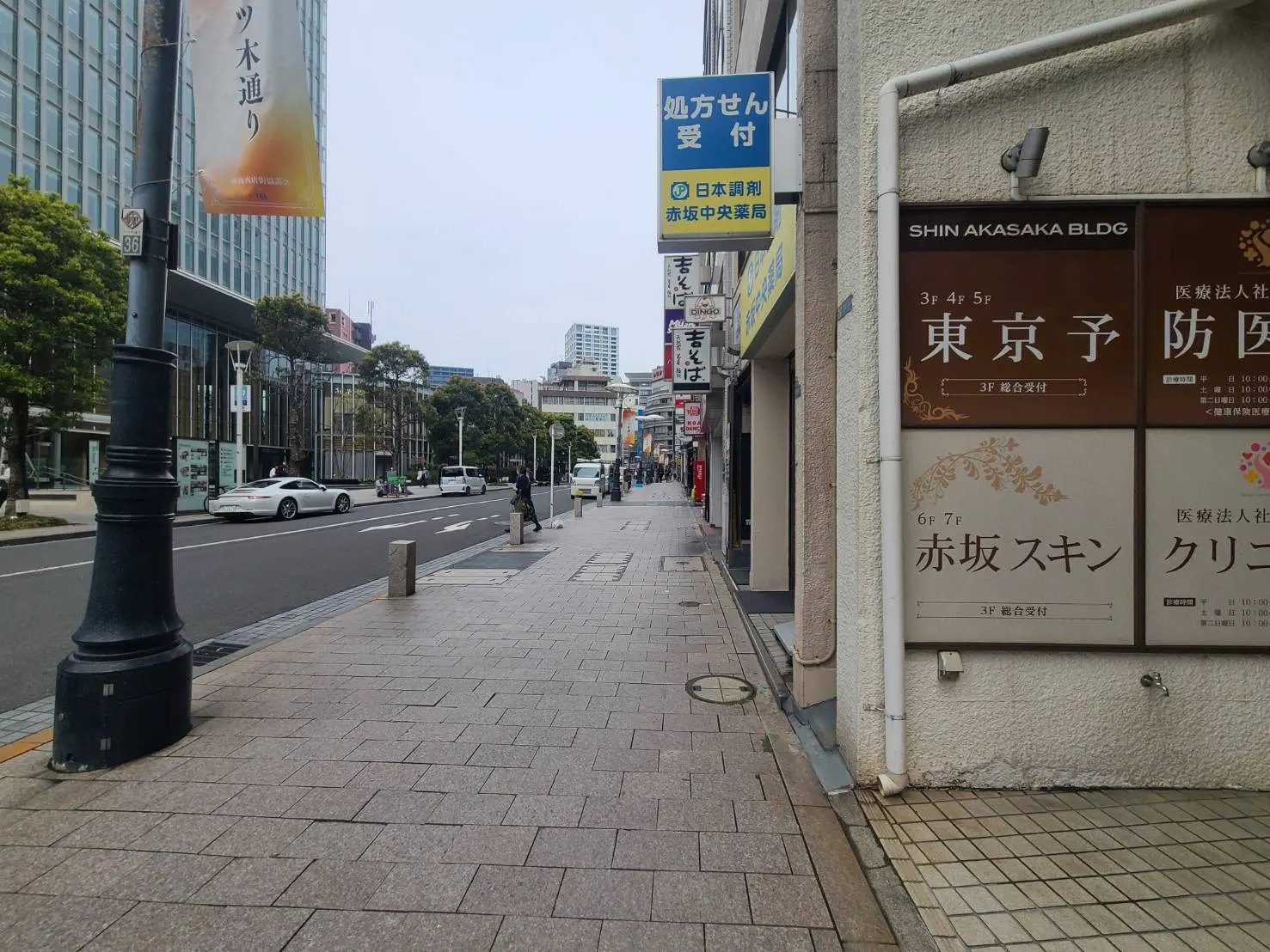 - 東京の赤坂にある商業ビルの外観、歩道沿いに並ぶ店舗と標識、静かな街並みの風景