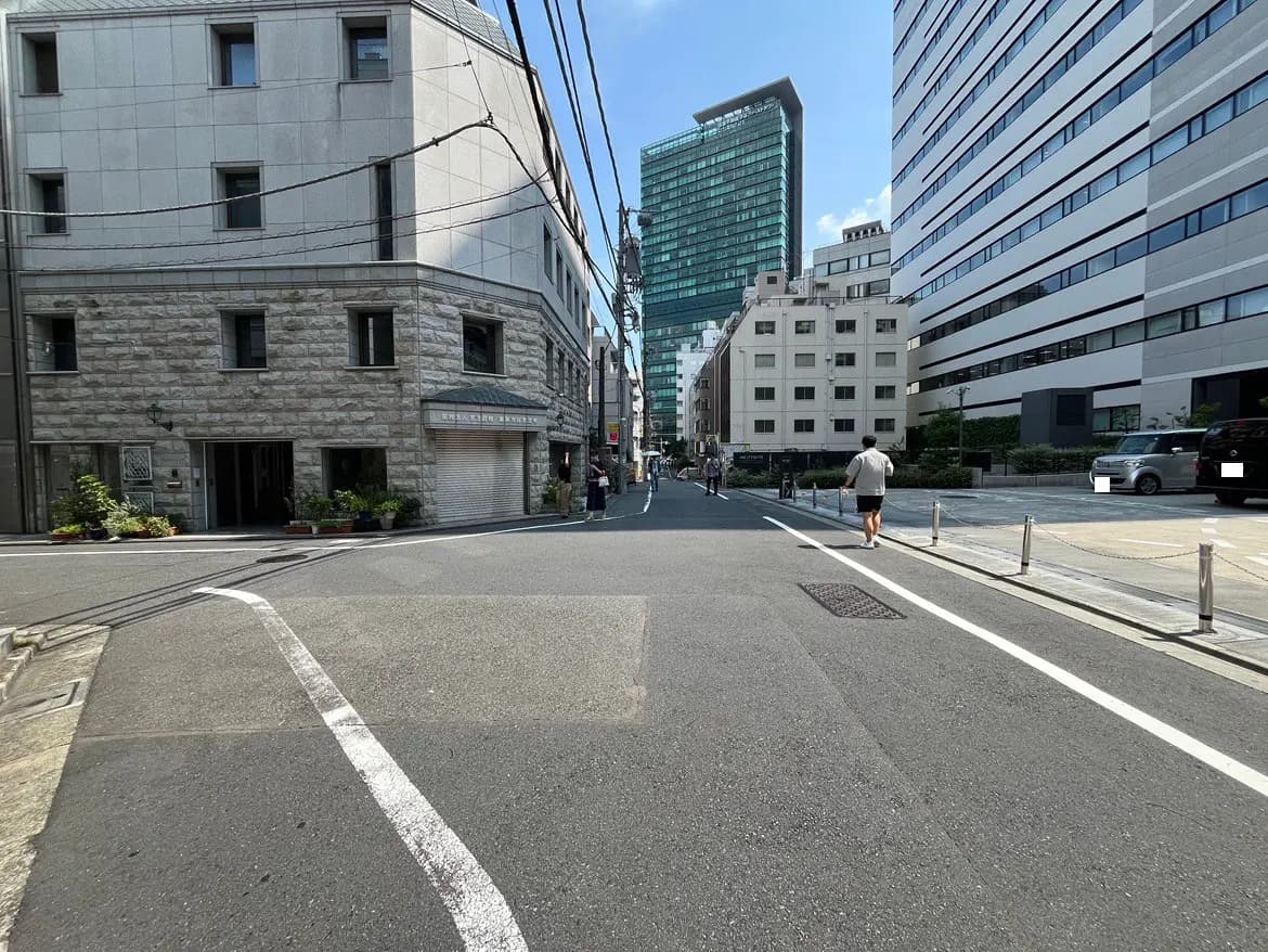 - 都市の交差点の風景、新旧の建物が立ち並び、歩行者が行き交う通りの様子