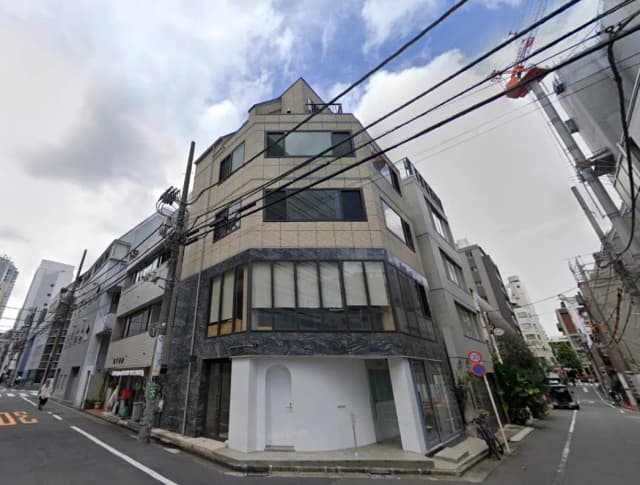 - 現代的なデザインのビル、ガラスの窓と特徴的な外観、周囲に街路樹や街灯のある通りの風景
