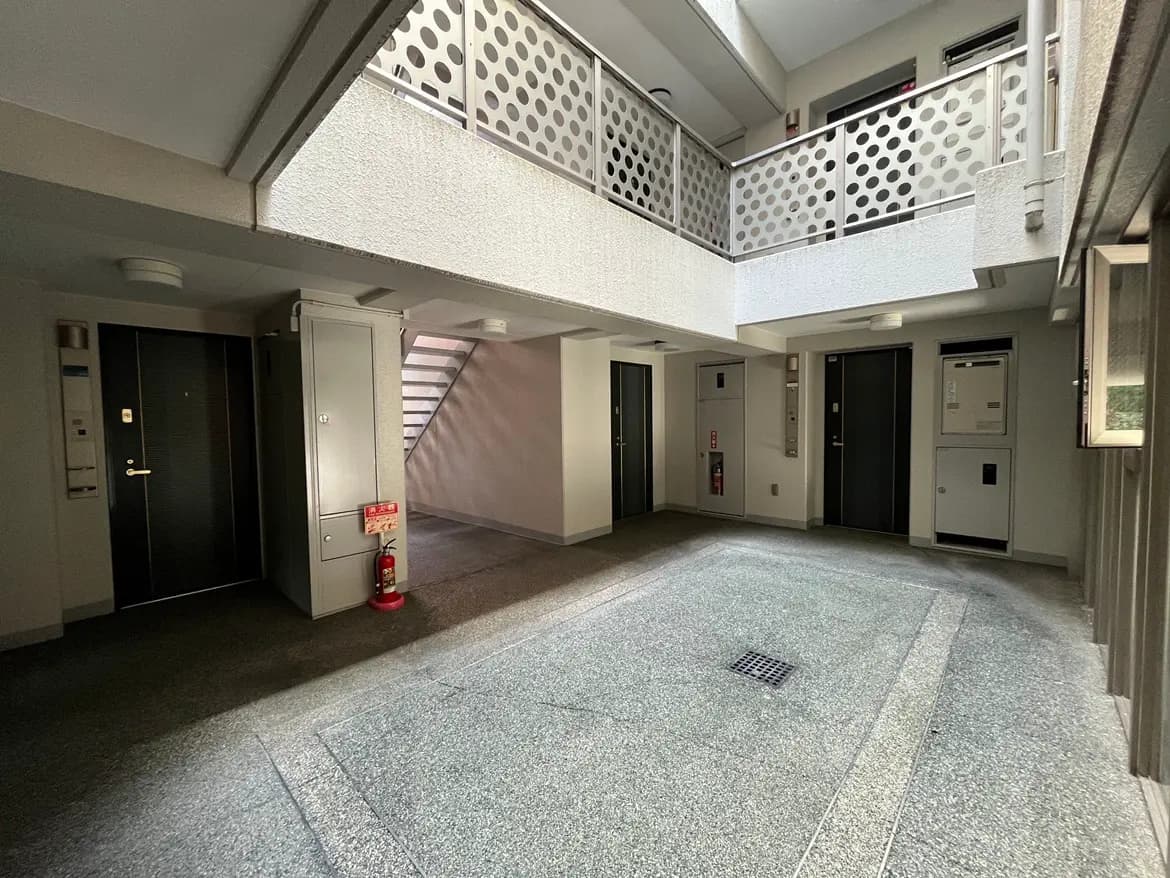 - 明るいインテリアのアパートのエントランスホール、階段と elevator のドアが見える空間