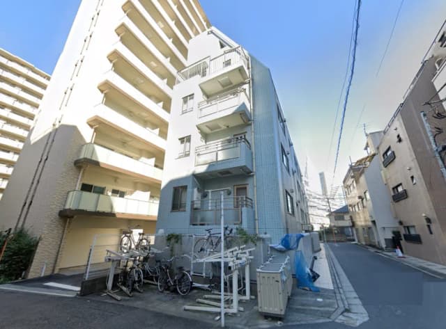 - 都市のアパートメントビルの外観、バルコニー付きの近代的な建物と自転車置き場が見える場所