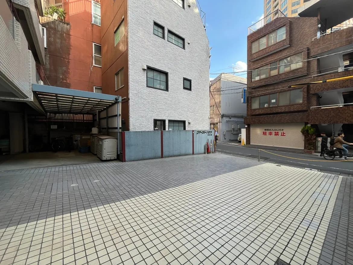 - 駐車スペースと周囲の建物、異なる外壁デザインと色合いのある都市の風景