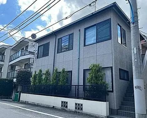 - シンプルでモダンな外観の住宅、窓が多く明るい印象、周囲には緑豊かな植栽が施された街並み