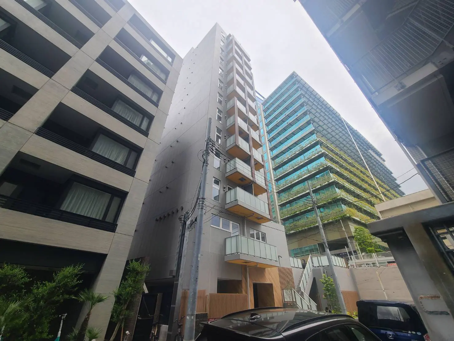 - 都市の風景に並ぶ高層ビル、ガラス張りの建物やバルコニー付きのマンションが特徴的な住宅街の一角