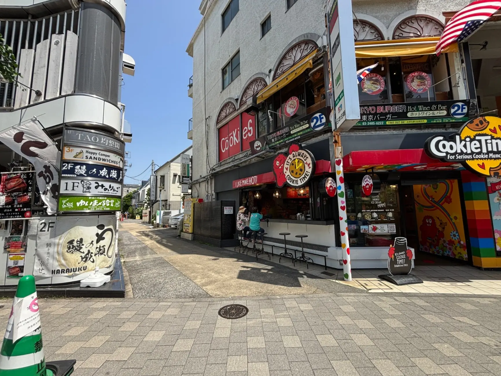 - 原宿の賑やかな通りに面したカフェとレストランの看板、青空の下にある賑やかな商業エリアの風景