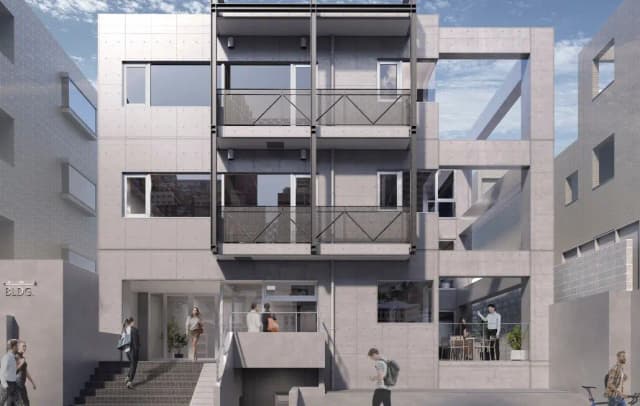 - コンクリートで造られたモダンな建物の外観、バルコニーと大きな窓が特徴のデザイン、周囲に人が行き交う都市の風景