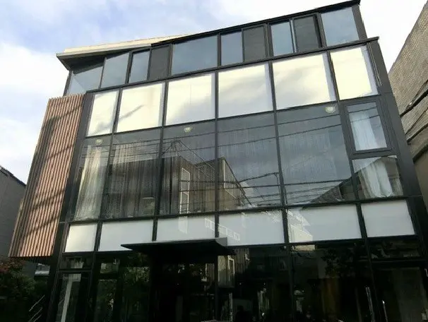 - 大きな窓が特徴的な現代的な商業ビルのファサード、木材のアクセントがある洗練されたデザイン