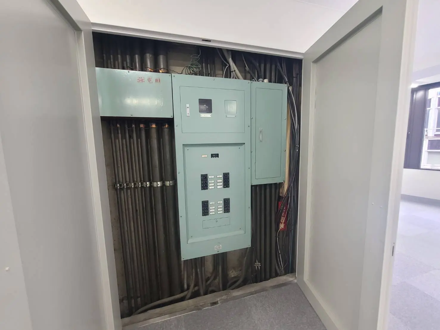 - 電気設備が設置された控え室で、配電盤と配線が確認できる内部の様子