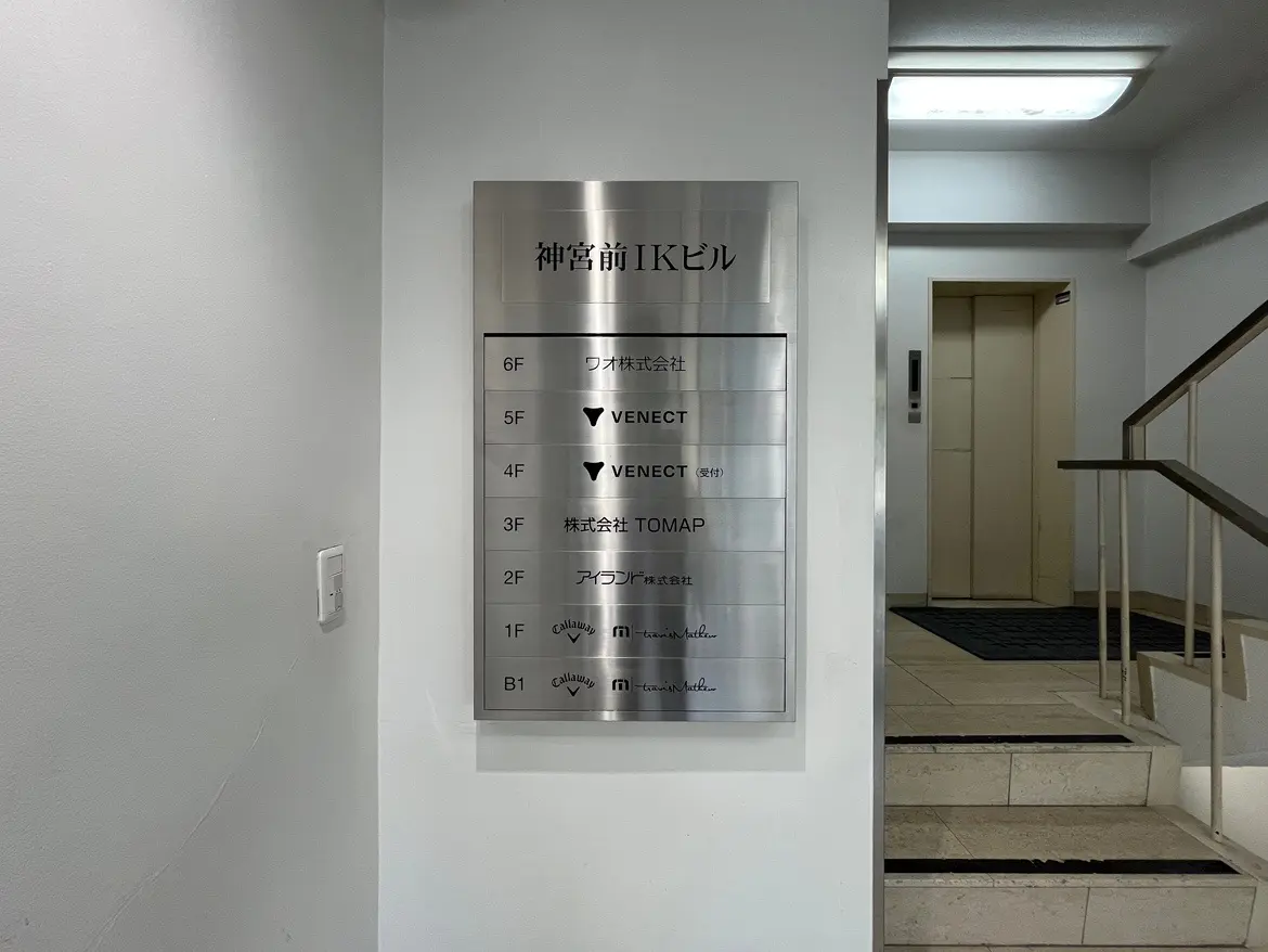 - 神宮前IKビルのフロア案内板、各階のテナント名が表示されたスタイリッシュなメタリックなデザインの看板