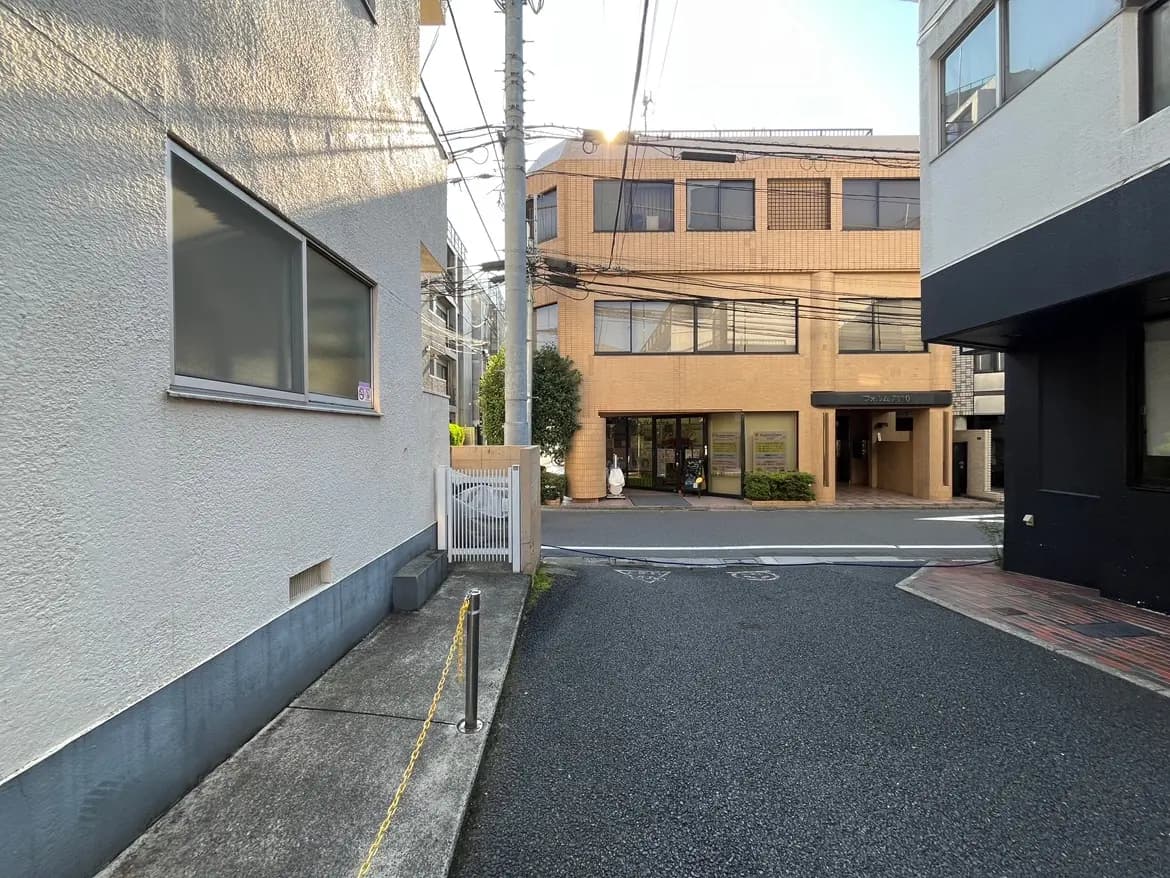 - 都市の道沿いの建物、白い壁の建物と窓、対面にあるビルと整然とした街並みの風景