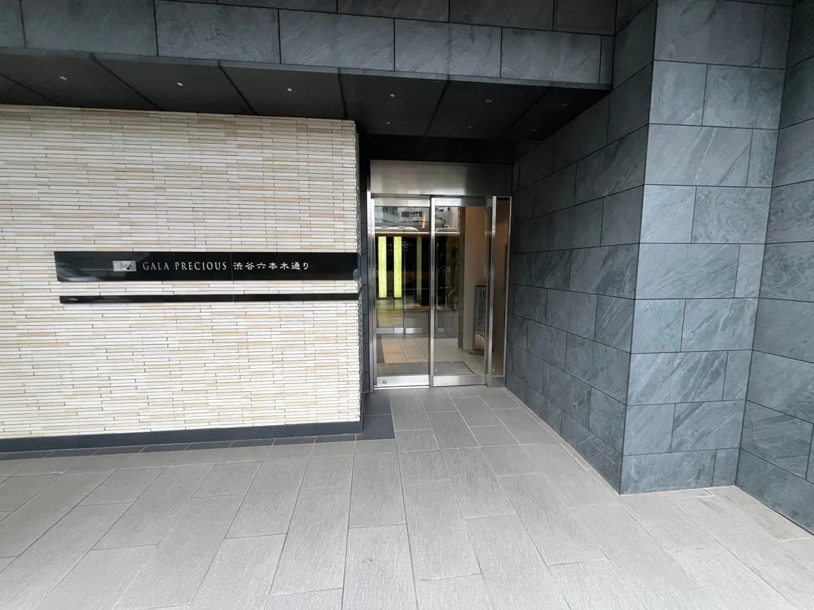 - 洗練されたデザインのエントランス、GALA PRECIOUS 渋谷六本木通りの看板が掲げられた建物の入り口
