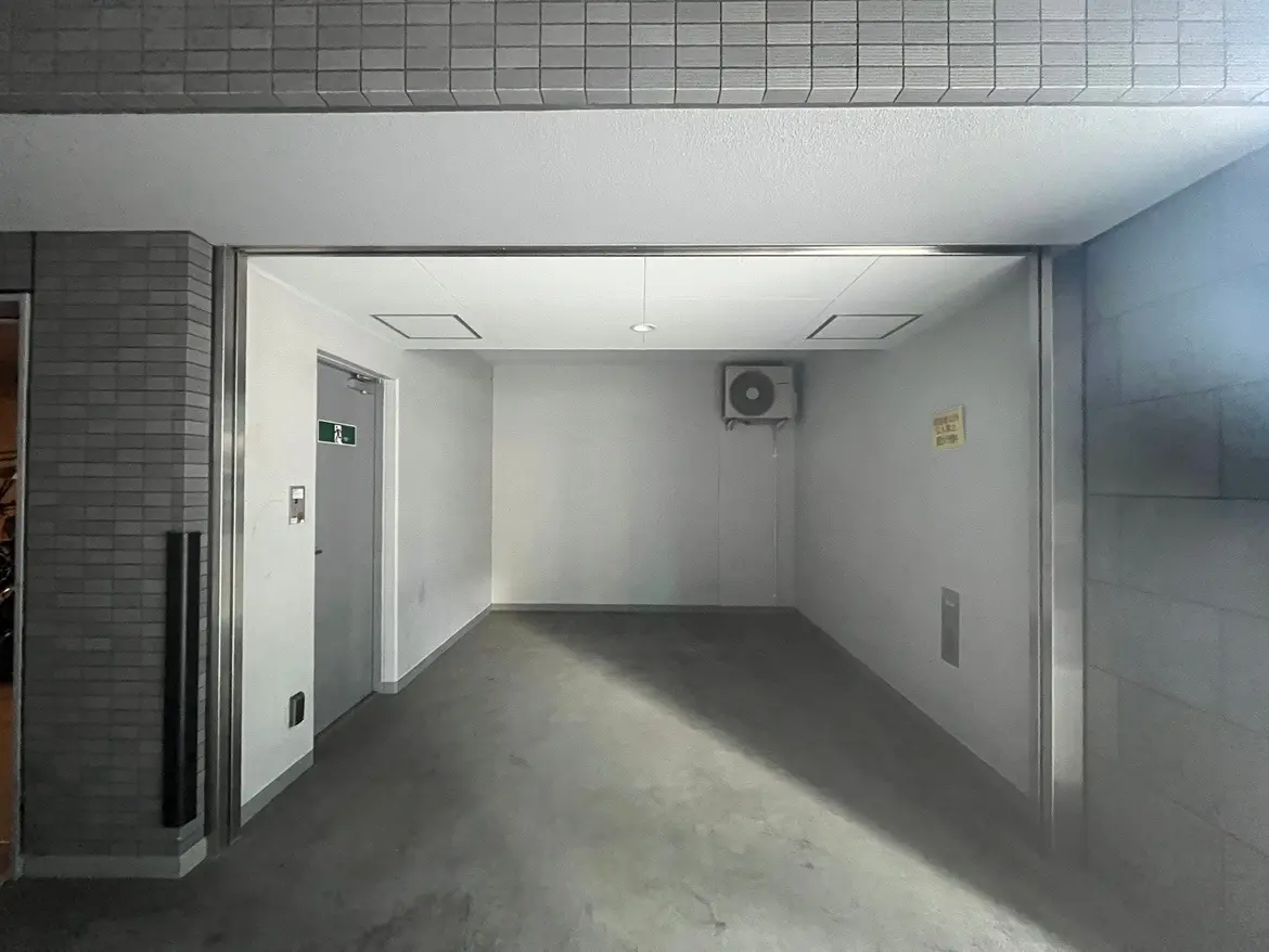 - 明るい室内の空間、白い壁と床、エアコンが壁に取り付けられたシンプルなデザインの部屋