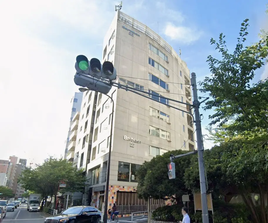 - 都心に立地するモダンなビル、緑豊かな街路樹と信号機が見える街並みの風景