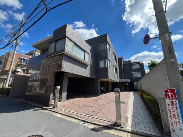 - モダンな外観の住宅、ガラスとタイルを使用したデザイン、青空を背景にした建物と敷地の様子