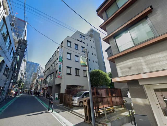 - 都心に位置する7-Elevenの店舗がある交差点、周囲にはビルと人々が行き交う街並みの風景