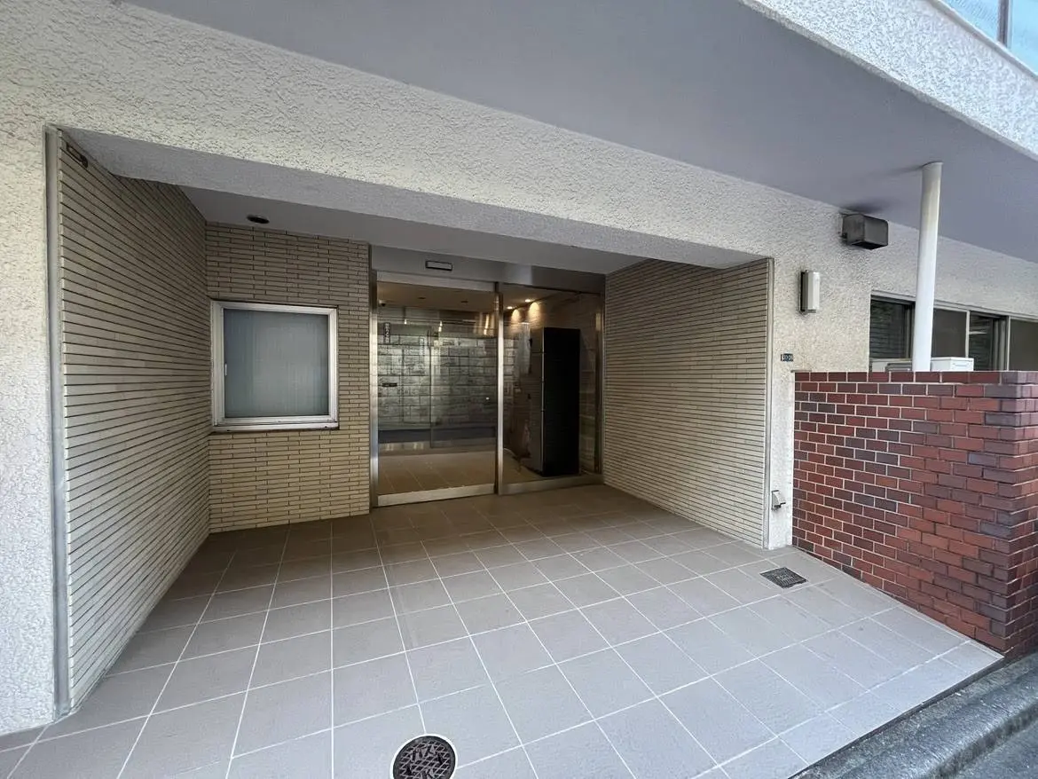 - 近代的なマンションのエントランス、スムーズなタイル張りの床とガラスのエレベーターがある静かな入口の様子
