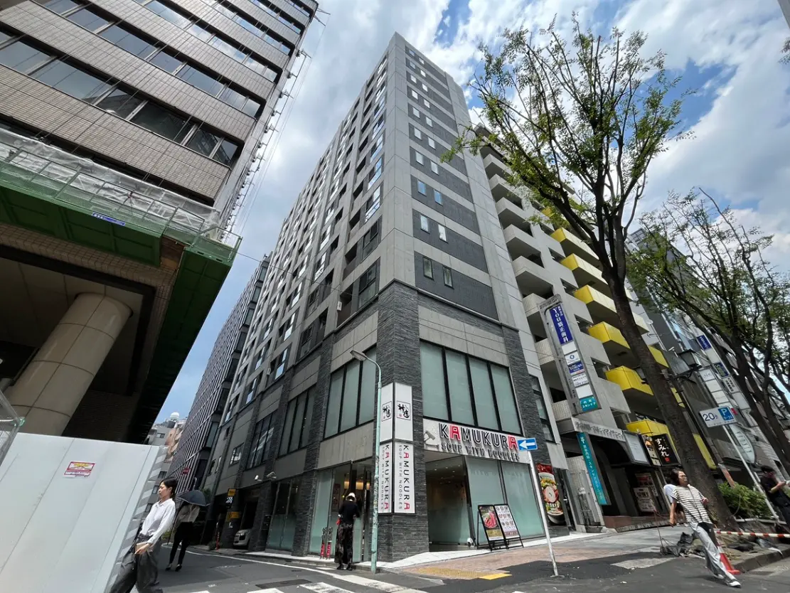 - 都市部のビル群、近代的なデザインの高層ビルと交差点、歩行者が行き交う街の風景