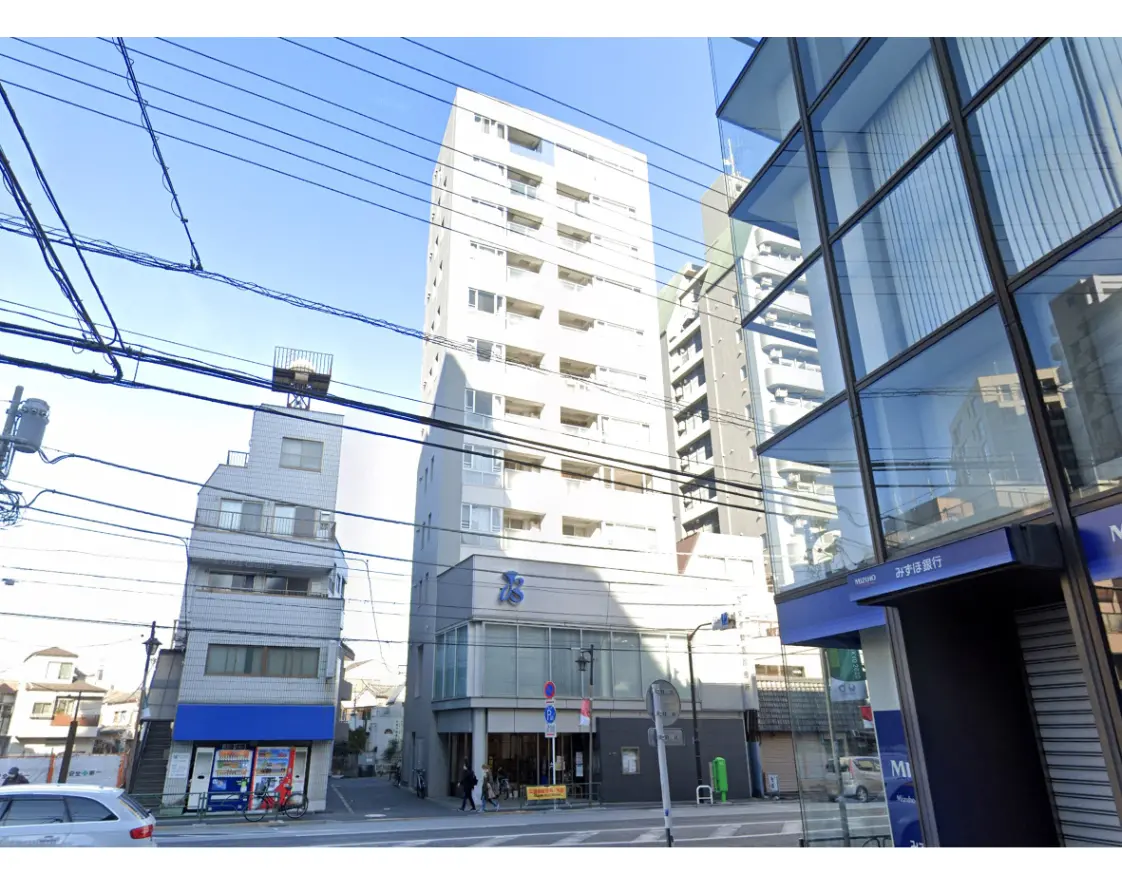 - 都市の風景、オフィスビルや住宅が立ち並び、交流のある街角、青空と電線が見えるバランスの取れた街並み