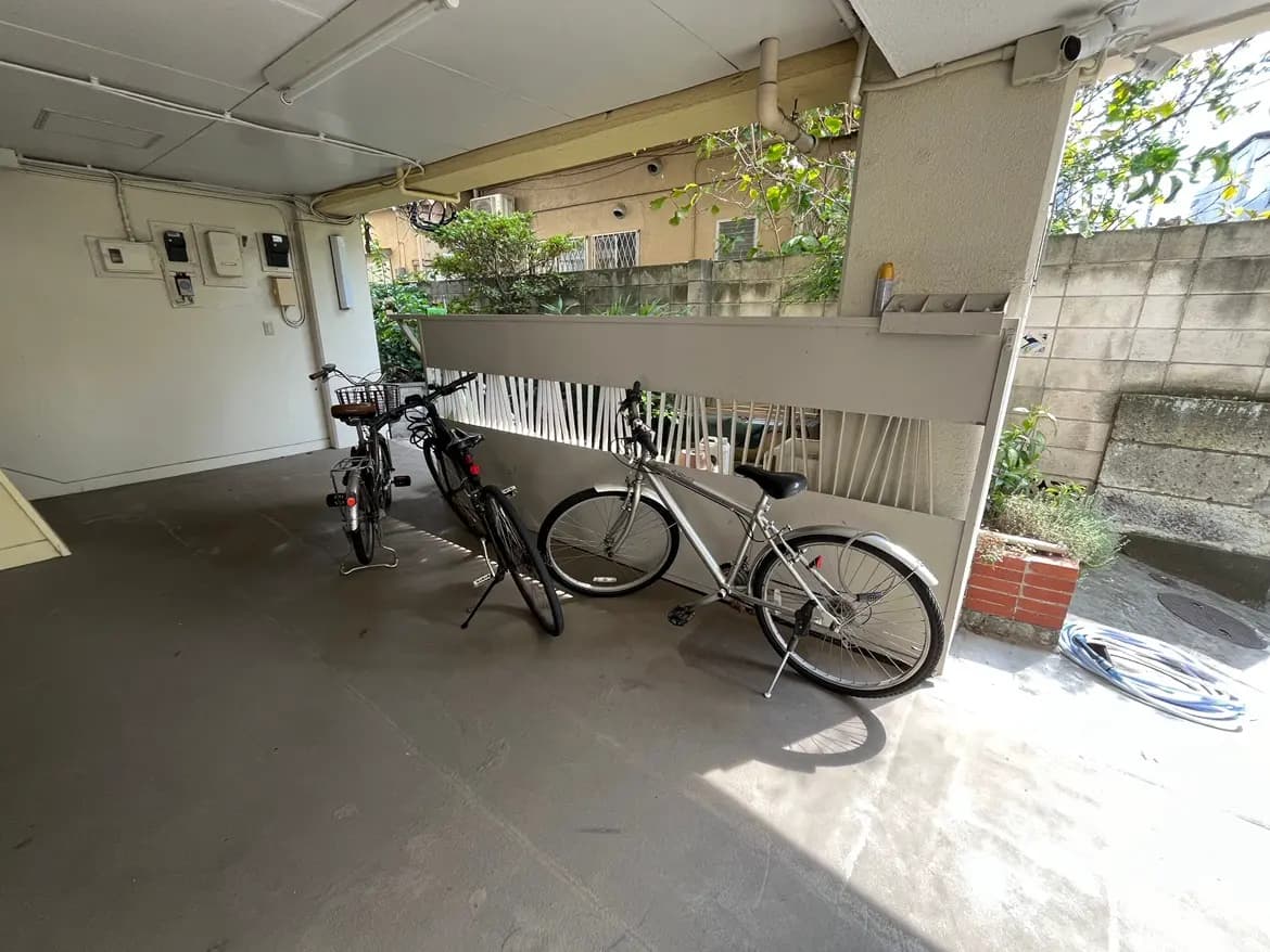 - 自転車が2台置かれた駐輪スペース、壁には植栽があり、空間に明るい自然光が差し込むインテリア