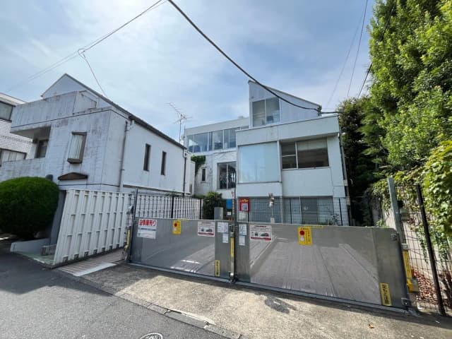 - モダンな建築デザインの住宅外観、白い壁と大きな窓、街中の光景が広がるエントランスの様子