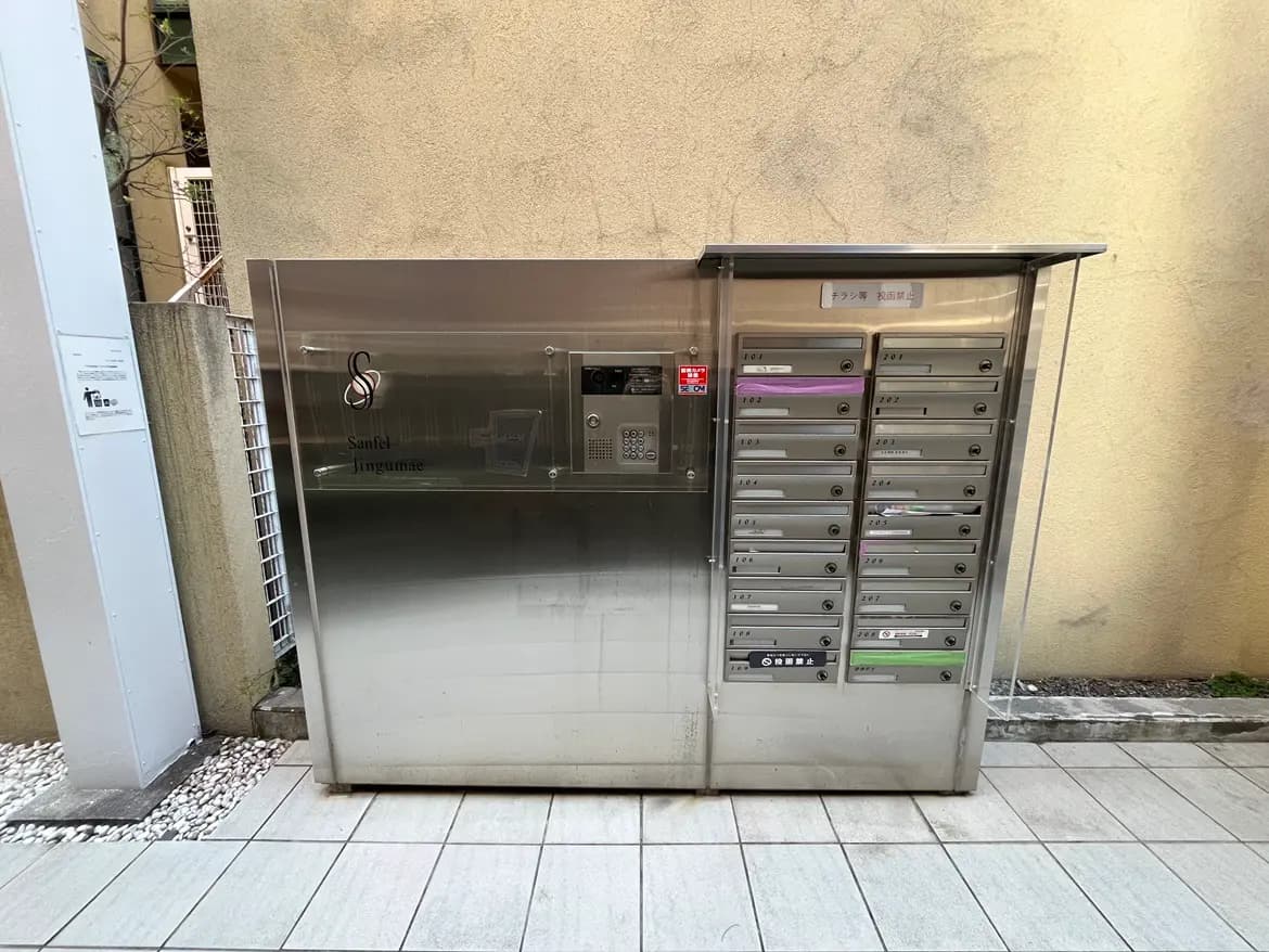 - ステンレス製の集合郵便受け、各部屋番号が記載されている、シンプルでモダンな外観のデザイン