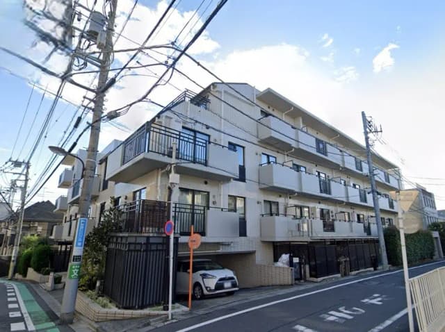 - モダンなデザインのアパートメントビル、バルコニー付き、周囲に電柱が立ち並ぶ街並みの風景