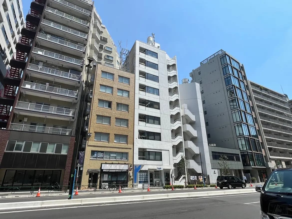 - さまざまなスタイルのビルが立ち並ぶ都市の風景、青空の下での賑やかな通りの様子