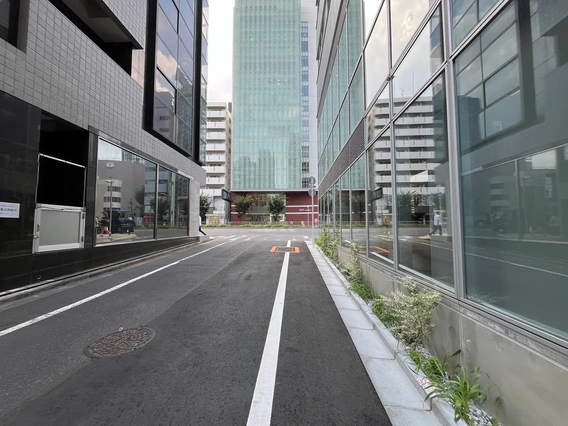 - 現代的なビルとアスファルトの道路、両側にガラスの窓を持つ建物が立ち並ぶシティスケープの風景