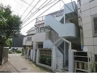 - 都市部に位置するシンプルな外観のアパートメント、緩やかな曲線の階段と周囲の緑が特徴的な景観