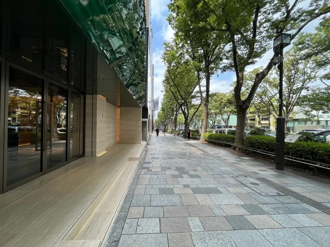 高級ブランドのブティックが並ぶ街並み、整然とした歩道と緑豊かな街路樹が印象的な風景