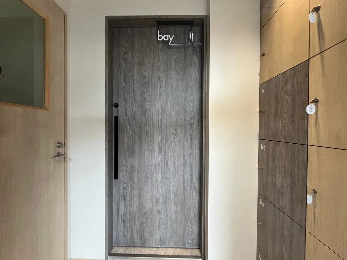 - 木目調の玄関ドアと隣接するロッカー、シンプルなデザインで落ち着いた雰囲気のエントランス