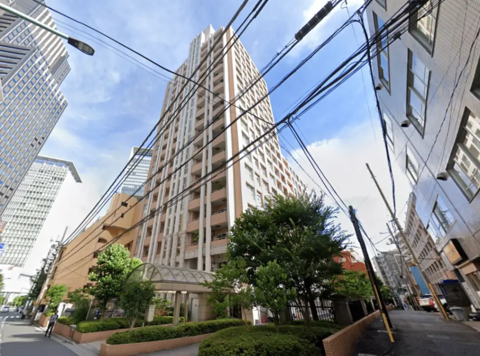 - 高層ビルと周囲の街並み、青空の下、電線が交差する都市風景