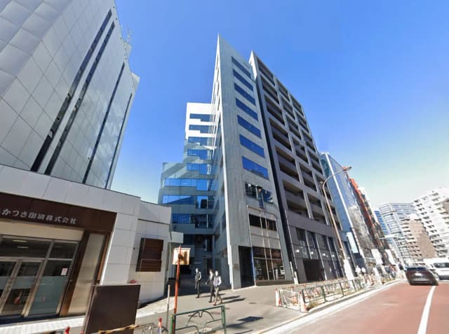 - 近代的なデザインのオフィスビル群、ガラス張りの外観とコンクリートの構造、青空が広がる都市景観