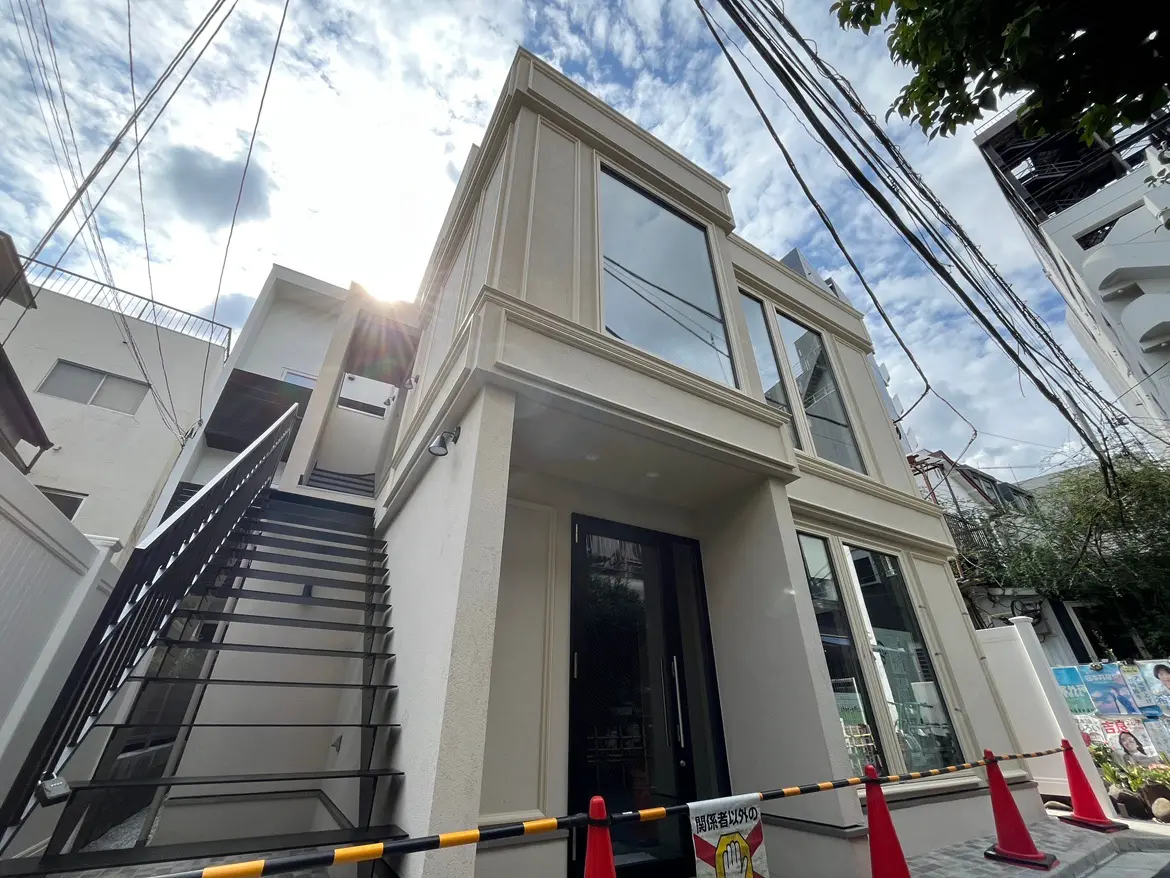 - モダンな外観の住宅、階段と大きな窓、青空と電線が写る魅力的なアングル